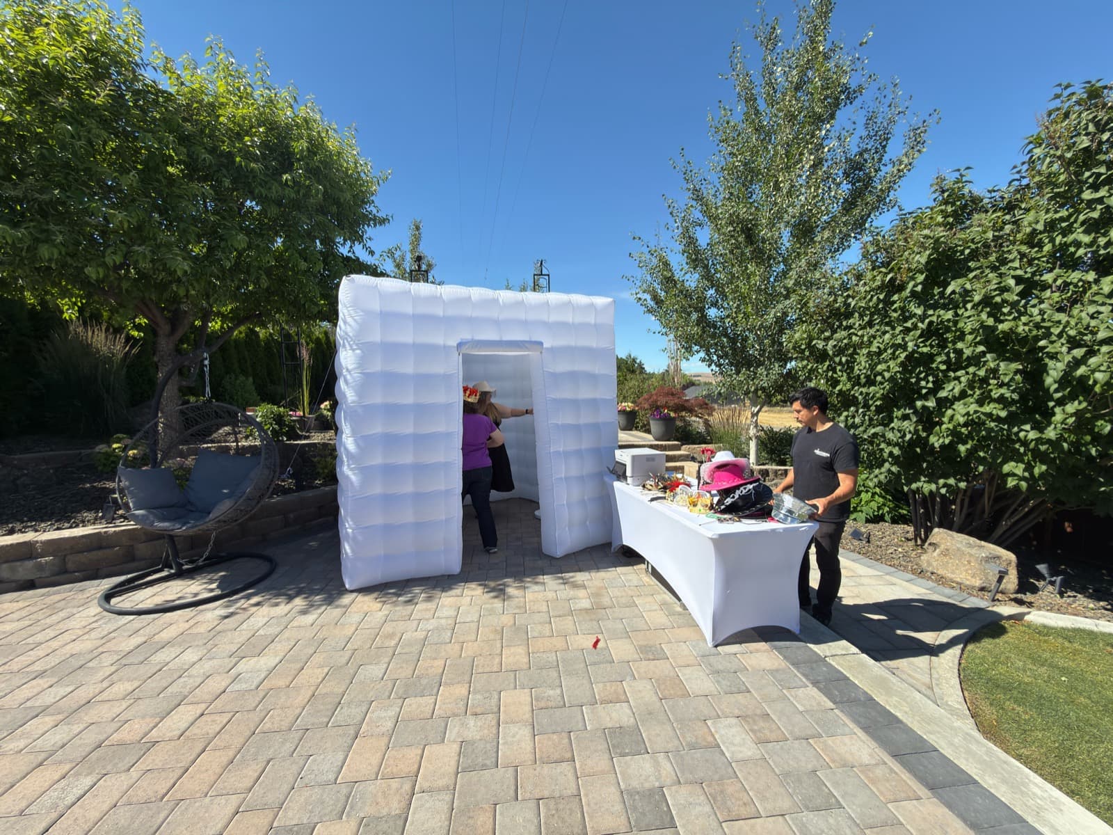 White inflatable photo booth setup with props table ready for guests